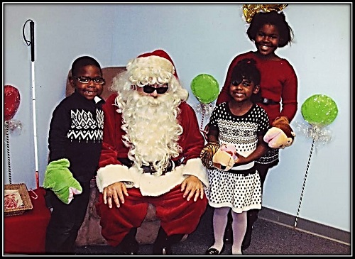 A family posing with blind Santa